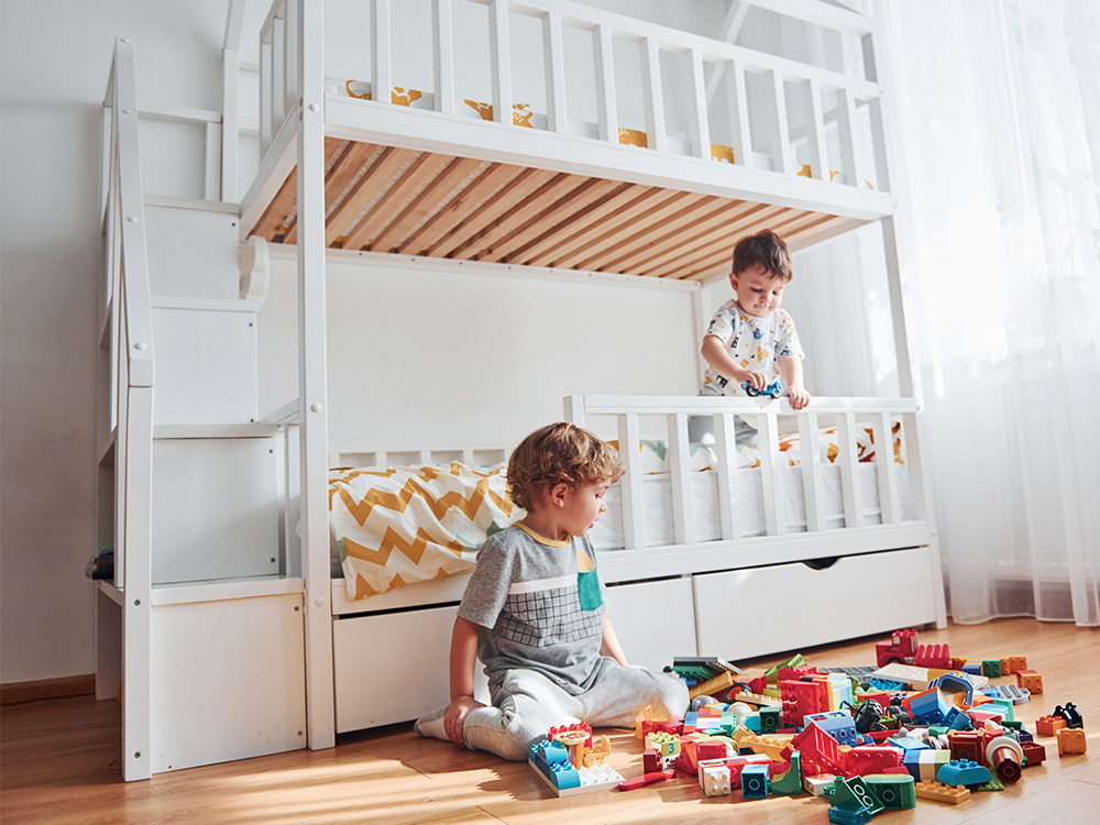 two kid playing in front of a bunk bed