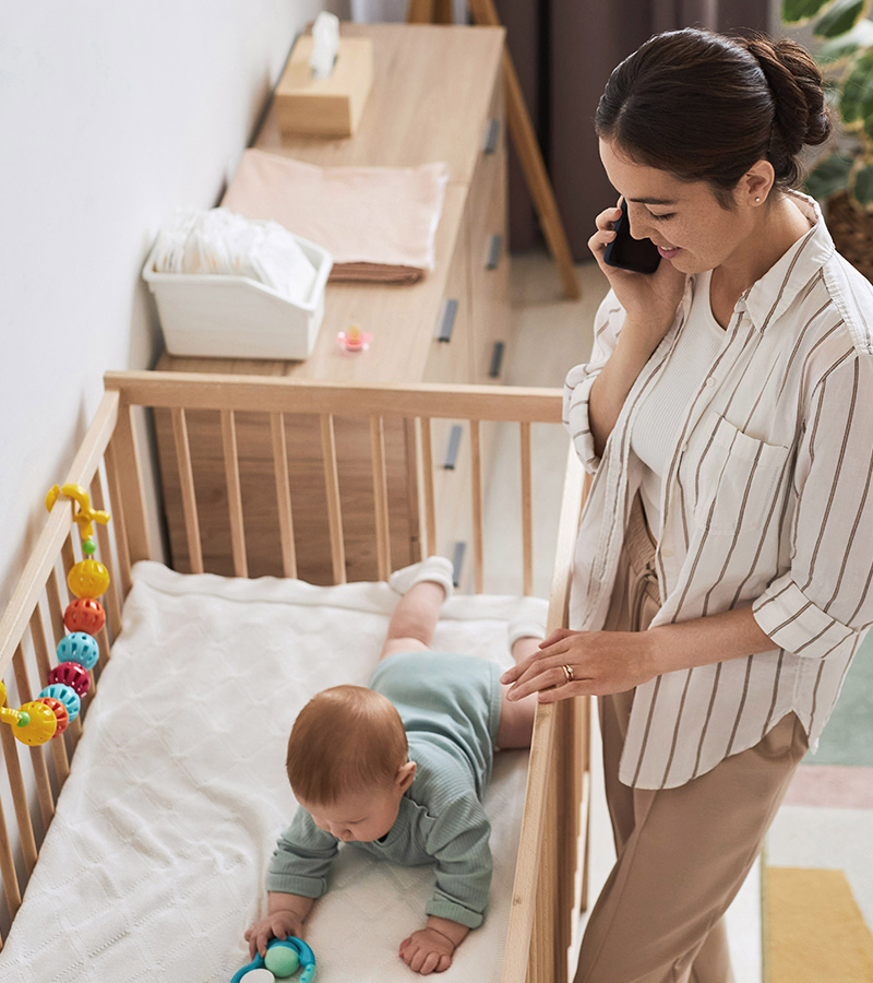 a mom taking care of a baby and having a phone call