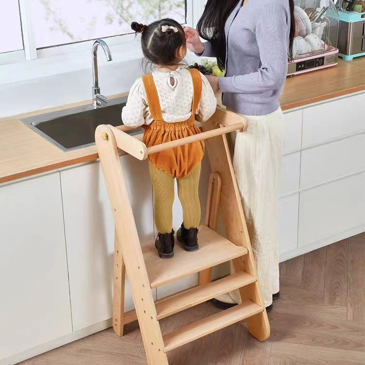 A child standing on a learning tower