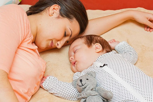 Pais e bebê dormindo na mesma cama